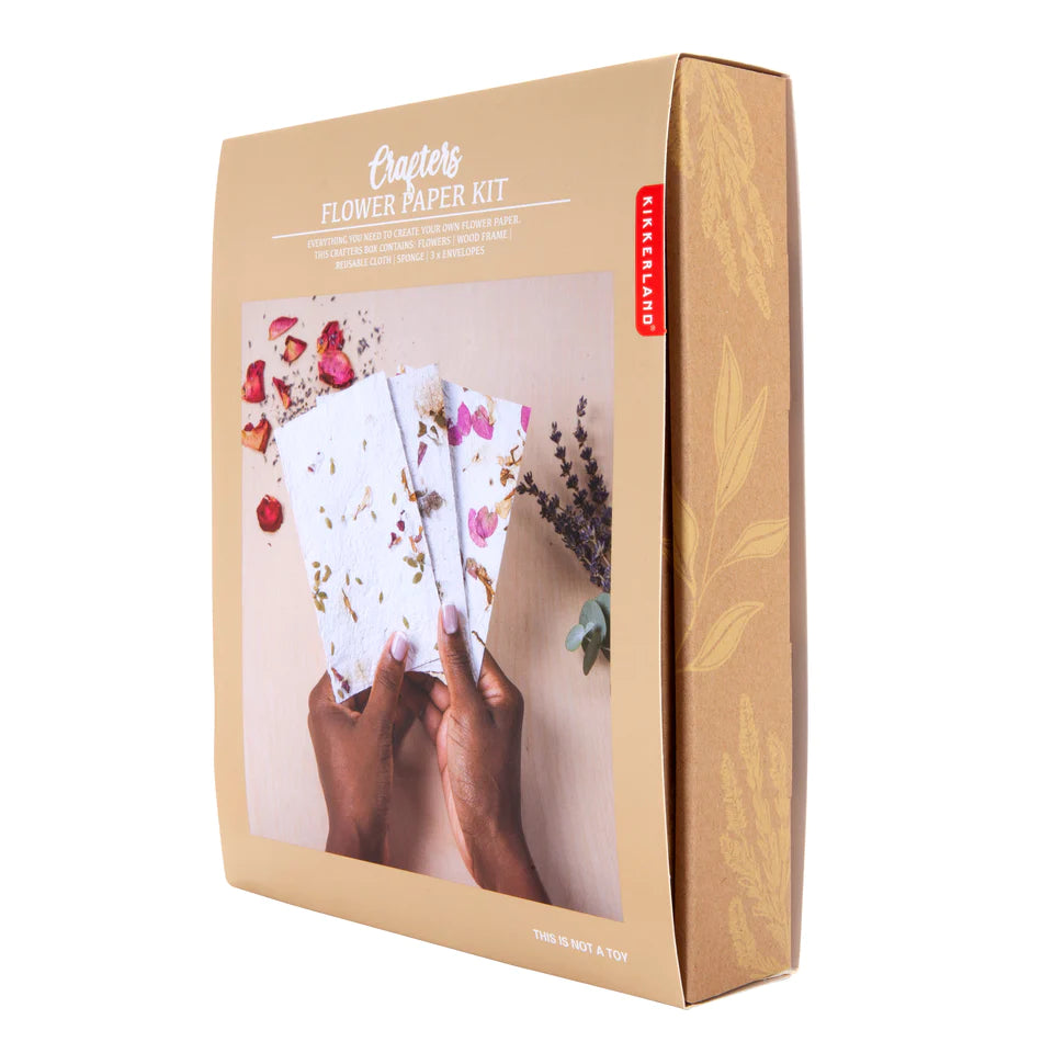 Light gold box shows hands holding hand-made paper with dried flower inclusions.